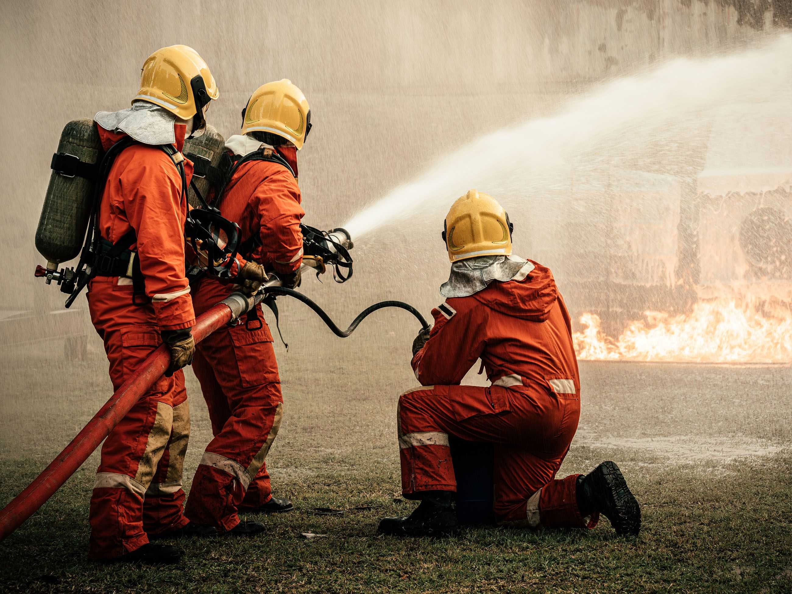 3 Feuerwehrmänner löschen einen Brand