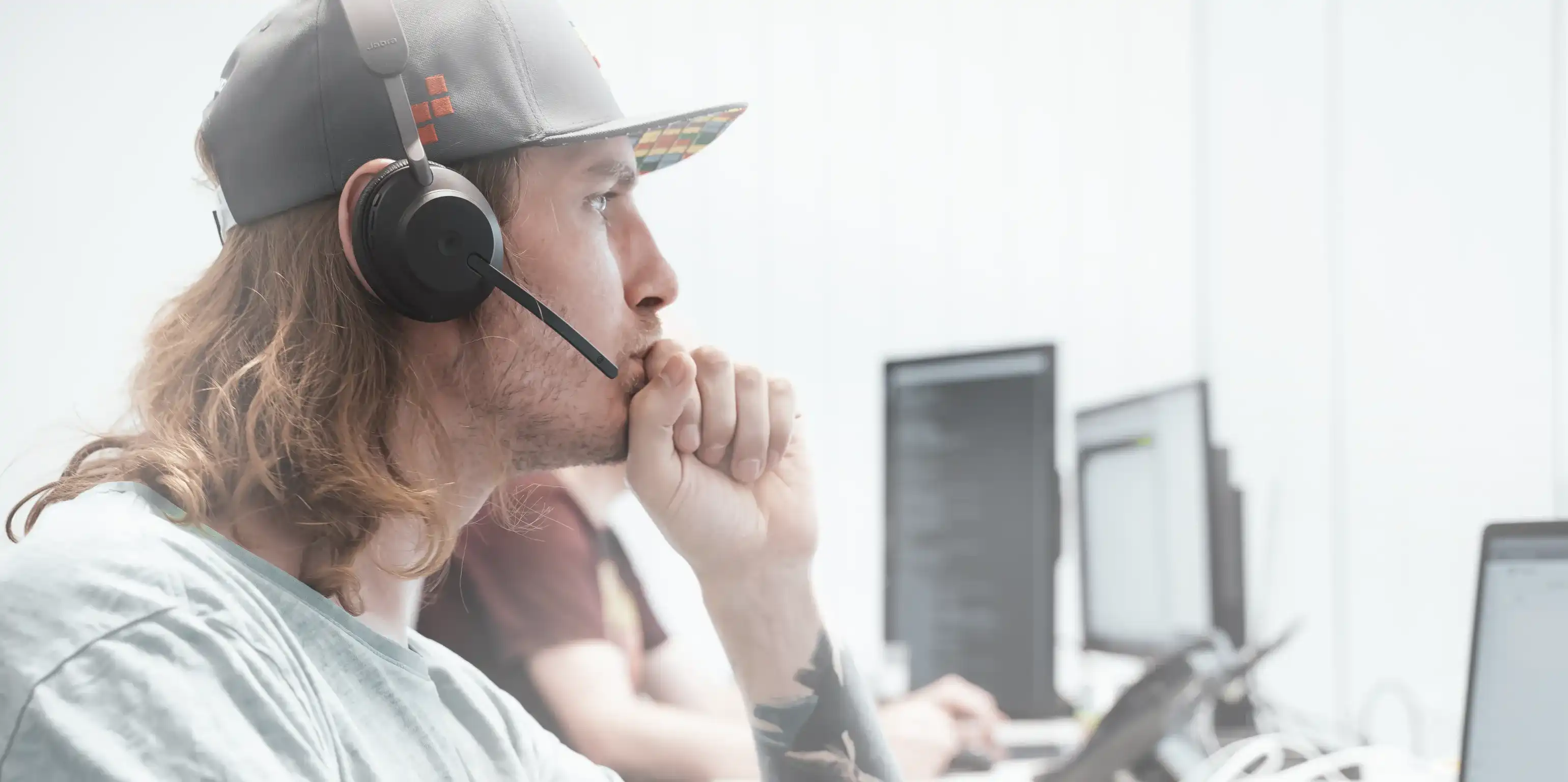 Relution Support Mitarbeiter Sergei Fink trägt ein Headset und blickt konzentriert auf den rechten Bildrand