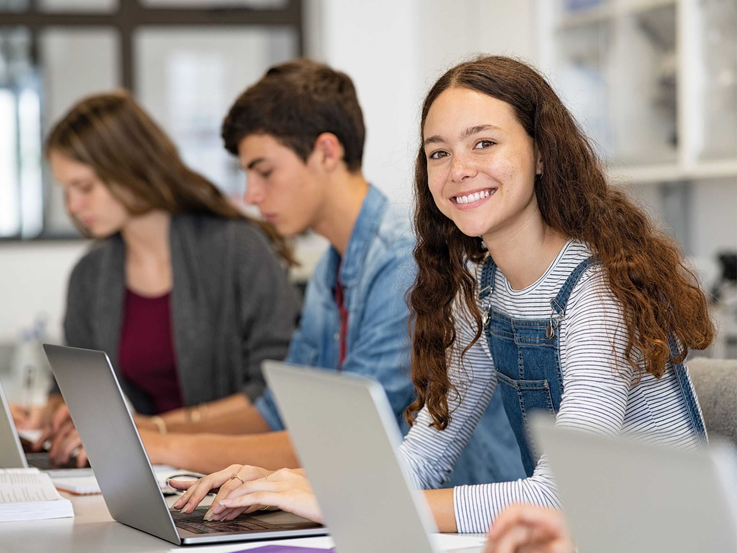 Jugendliche vor Rechner und Tablets im Klassenzimmer