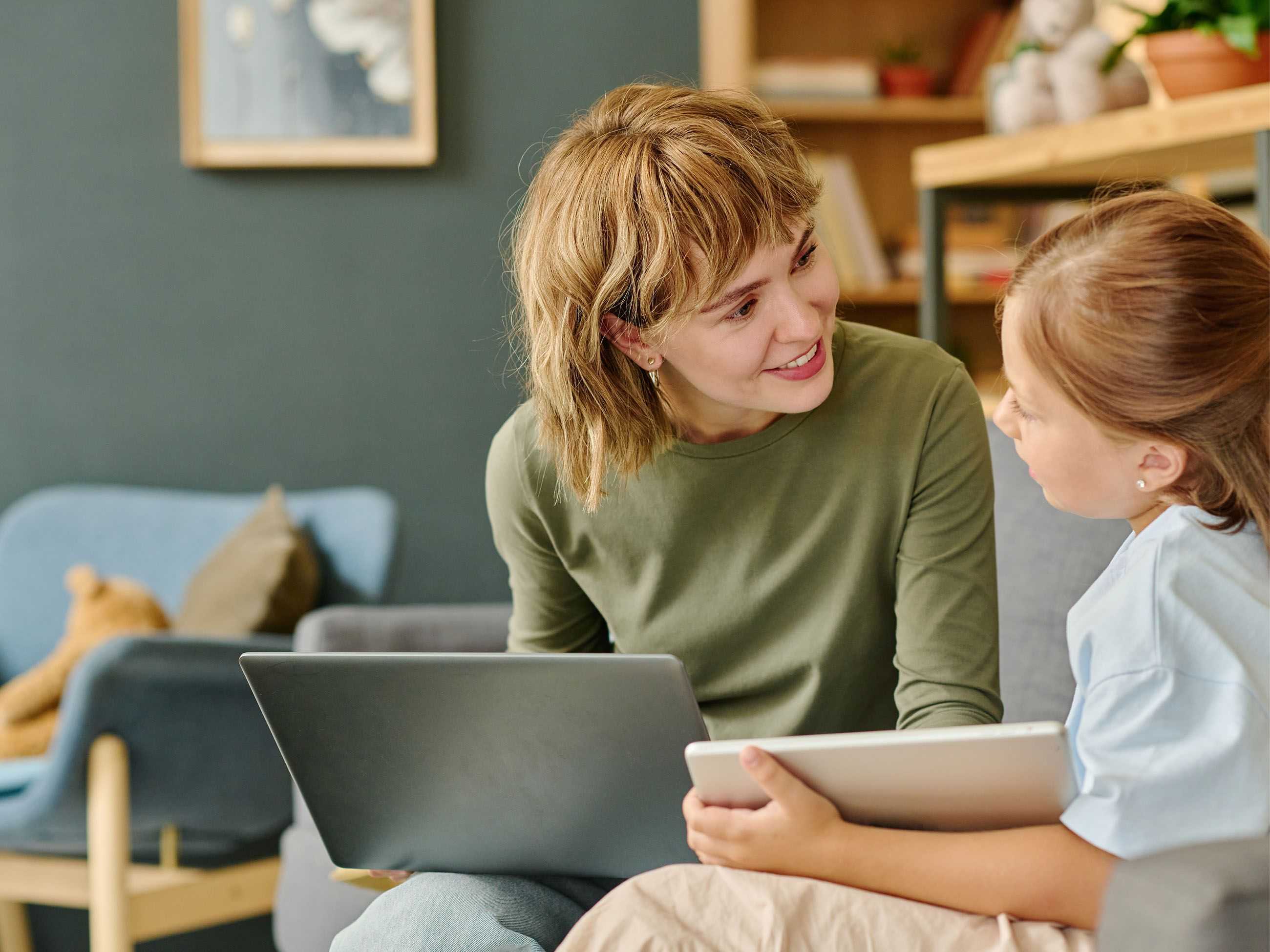 Mutter zeigt Kind am Tablet eine Aufgabe