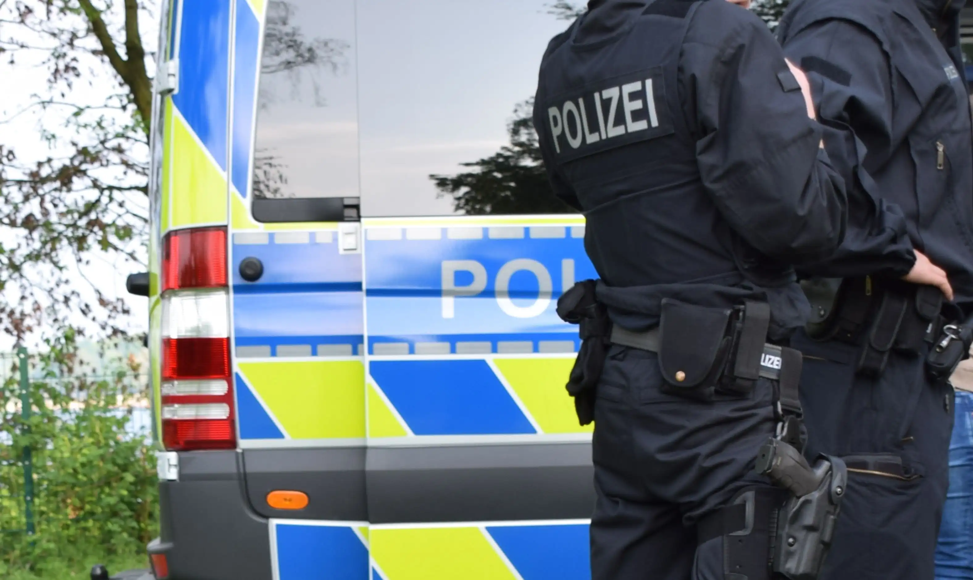 olizeibeamte in Uniform stehen neben einem Polizei-Einsatzfahrzeug