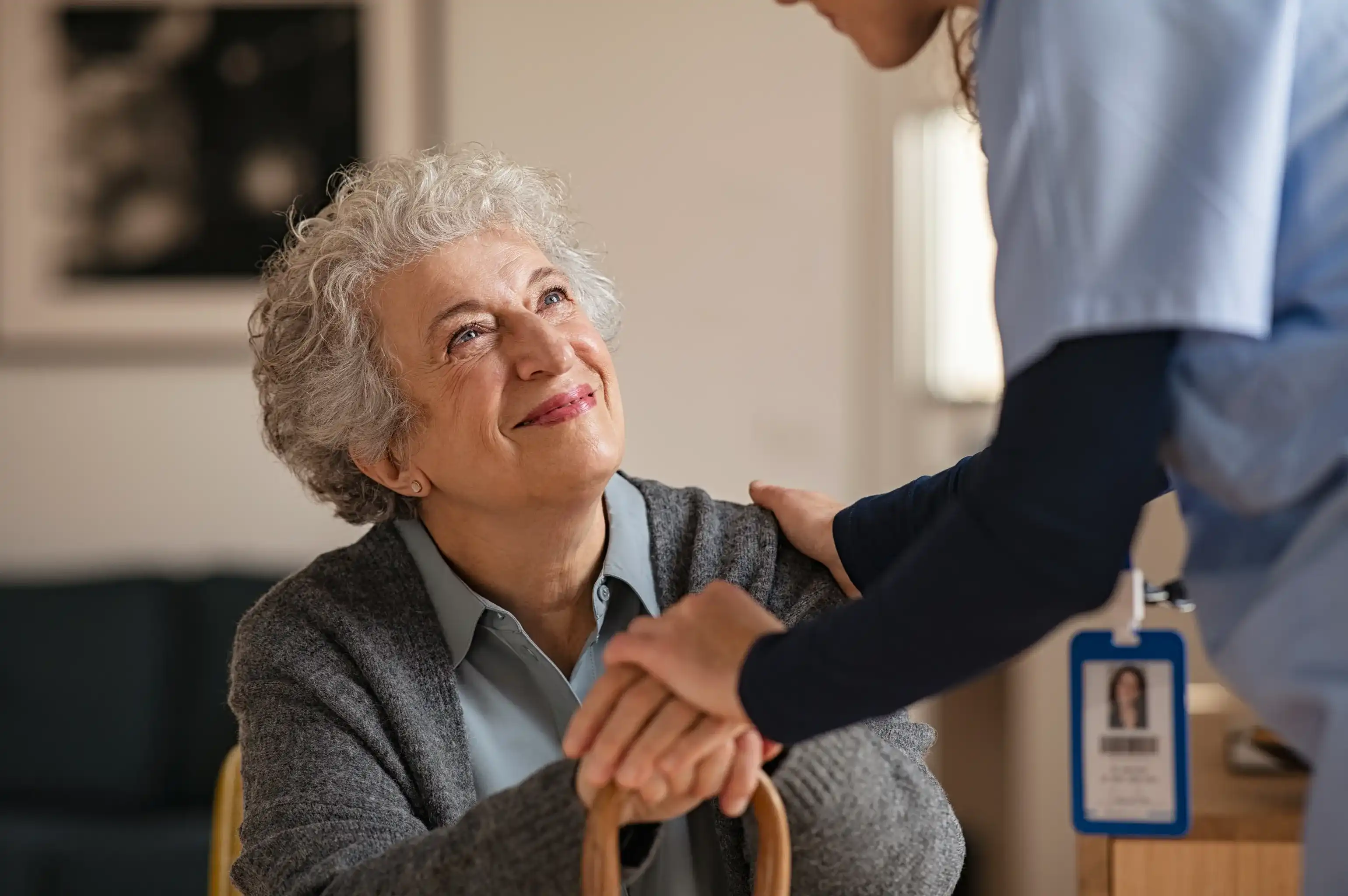 Una donna anziana sorridente viene assistita da un professionista medico