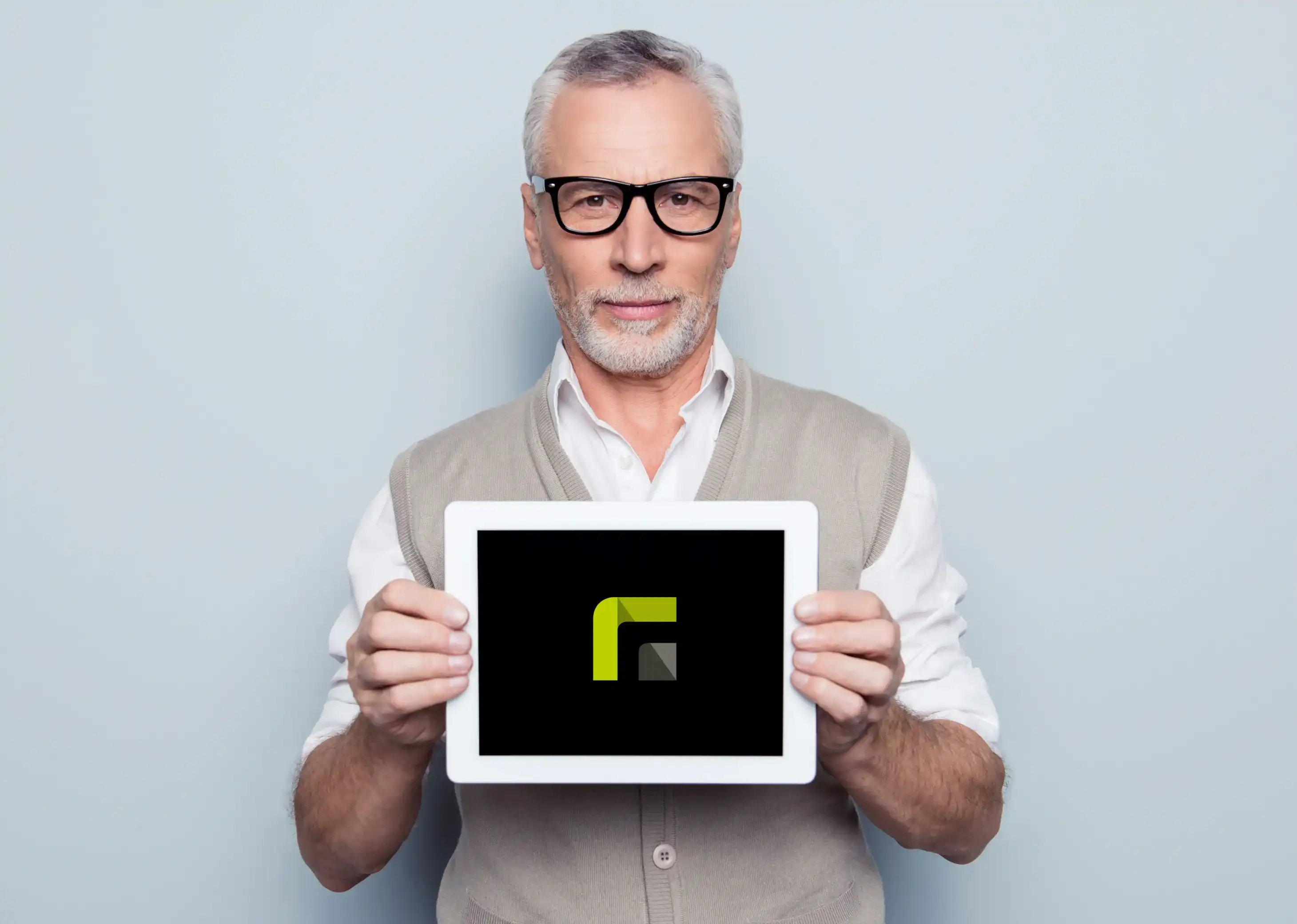 Un hombre mayor con gafas sostiene una tableta con el logotipo de Relution frente a la cámara, sobre un fondo azul claro.