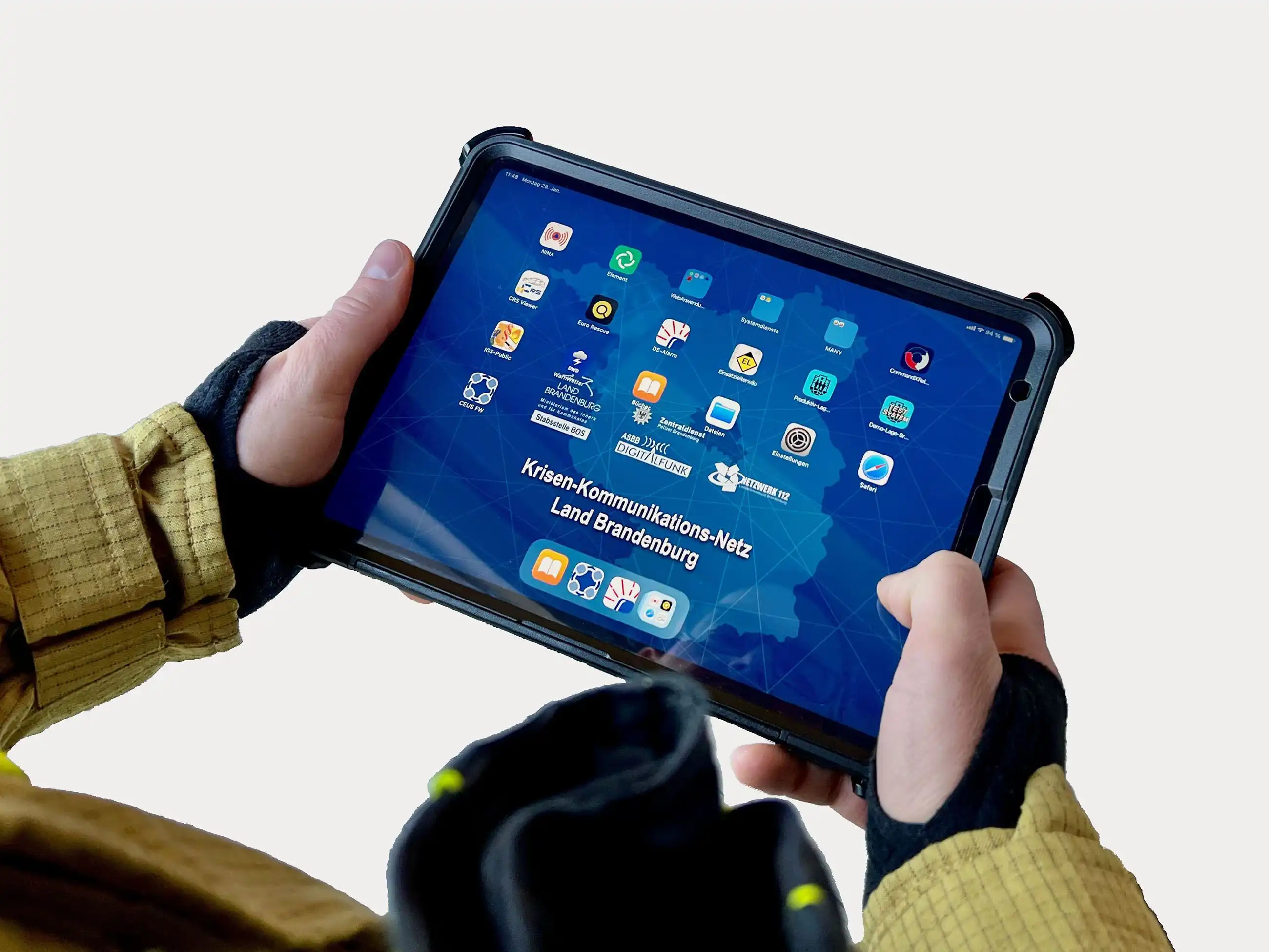 Zwei Hände halten ein iPad, auf dem Krisen-Kommunkiatons-Netz Land Brandenburg und weitere entsprechende Apps abgebildet sind