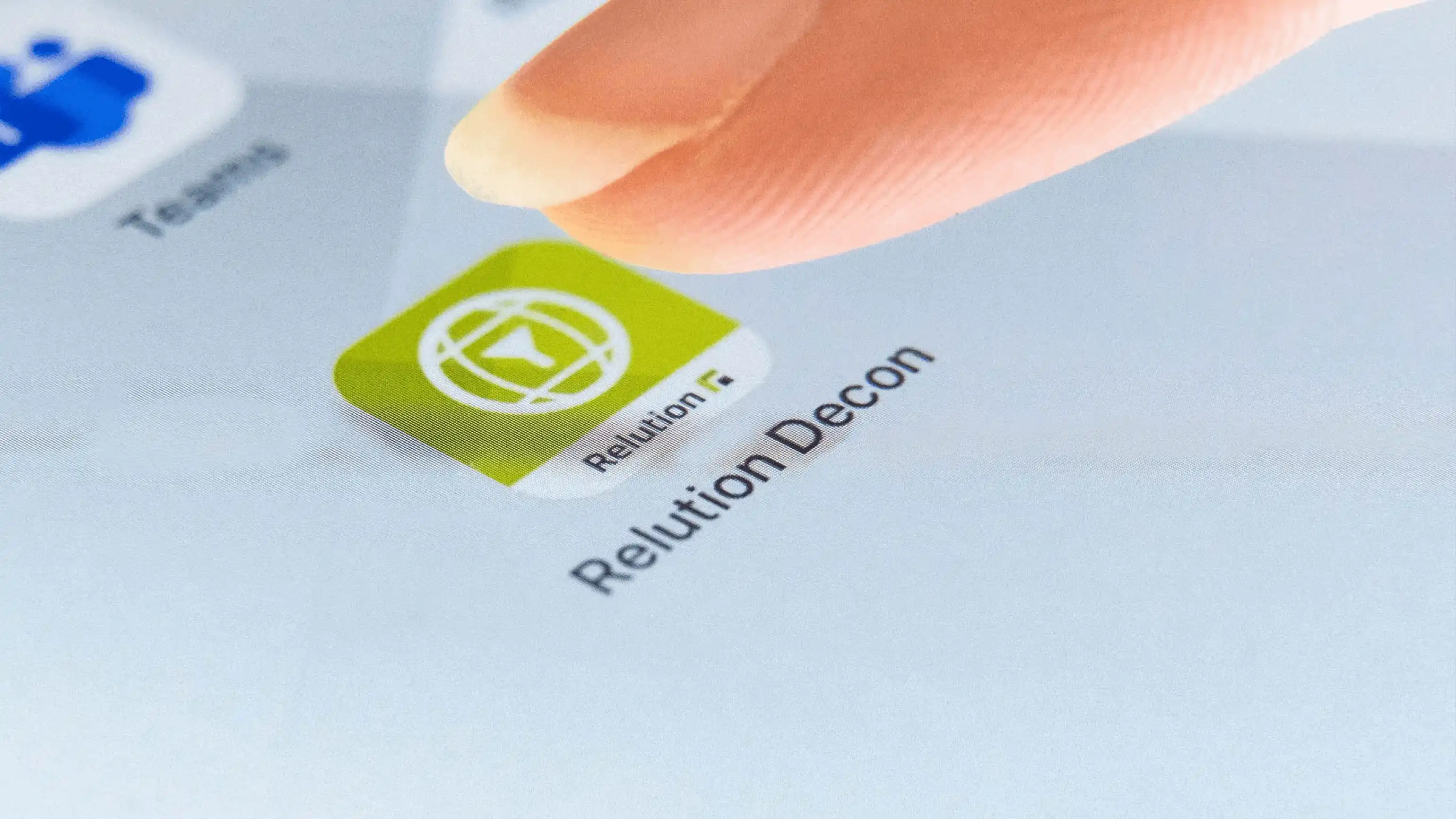 Ein Finger nähert sich auf einer Touchoberfläche dem Symbol von Relution Decon