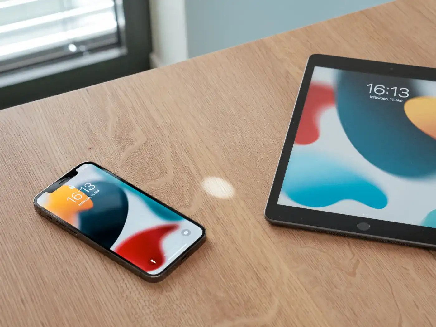 Ein Smartphone und ein Tablet auf einem Tisch, beide haben dasselbe Hintergrundbild