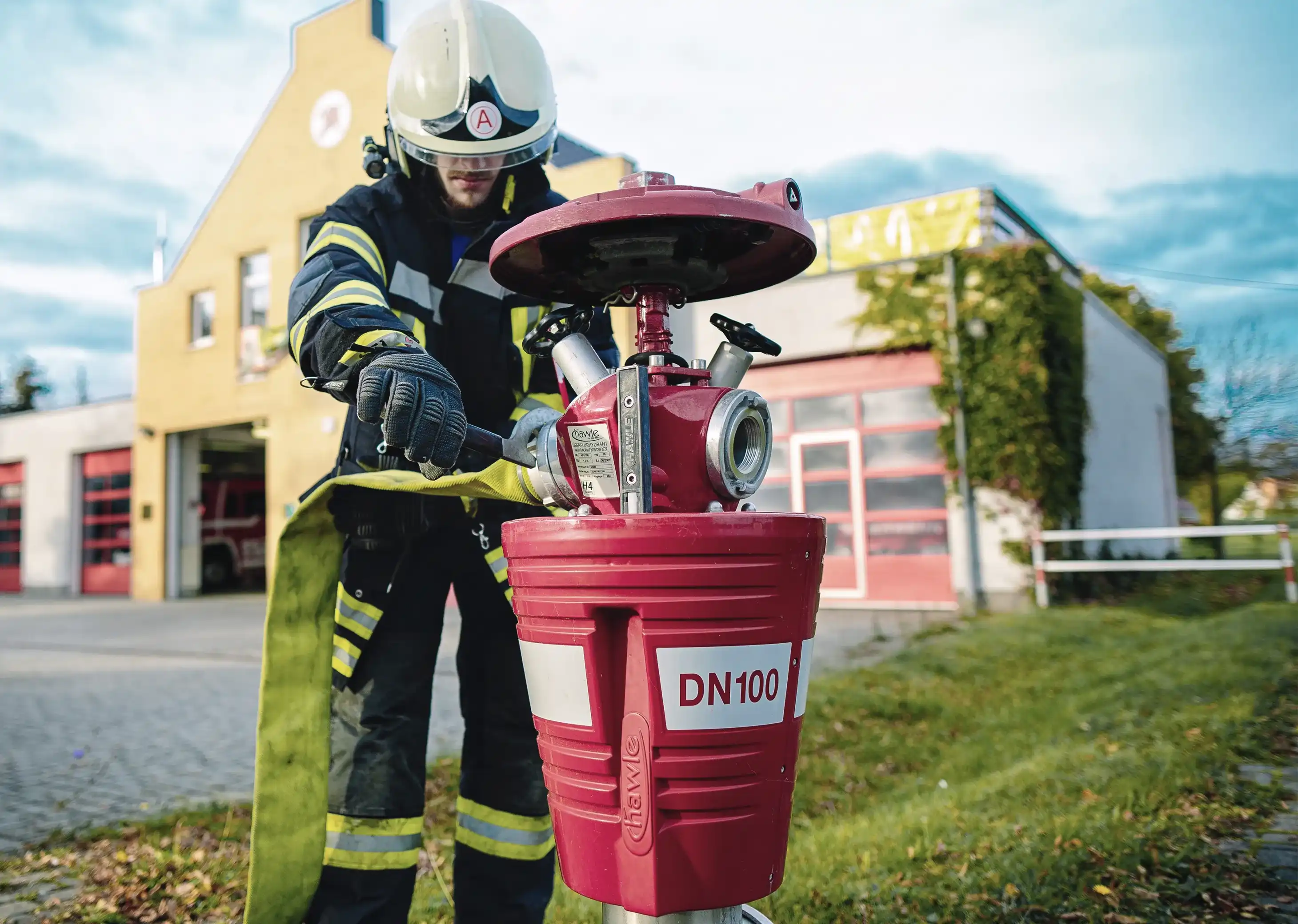 Mitarbeiter der Ortfeuerwehr Blankenfelde-Mahlow schließt einen Schlauch an einen Hydranten an