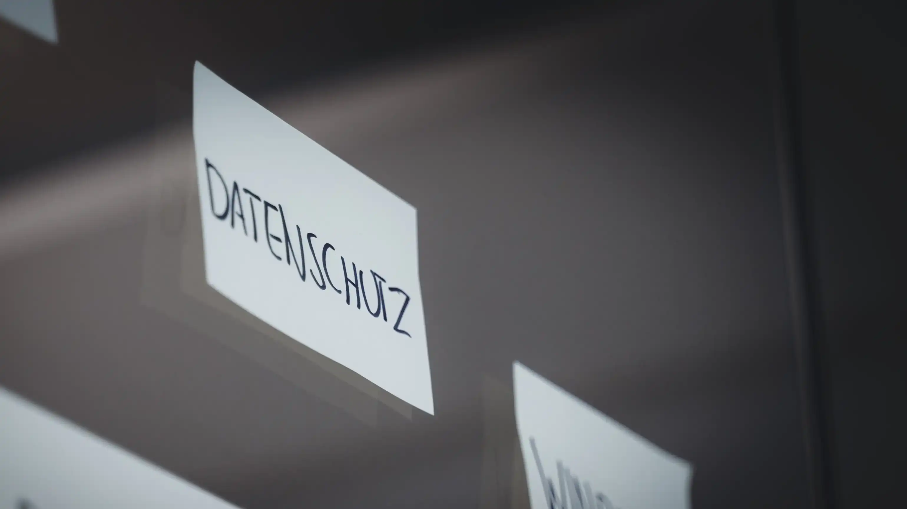 Un Post-it è attaccato a un vetro, con la parola « Datenschutz » scritta sopra