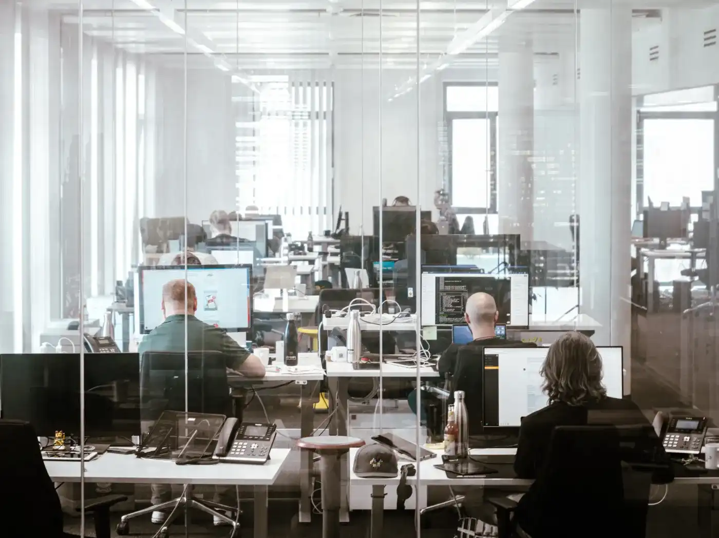 Un bureau moderne avec de nombreux postes de travail équipés de portables et d'écrans